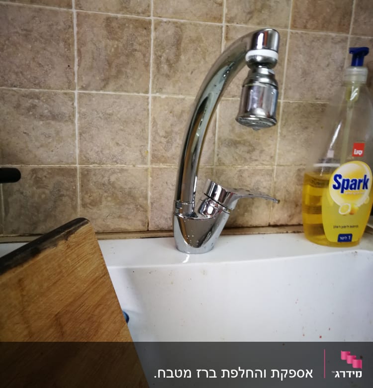 ברז מטבח כסוף מעל כיור לבן